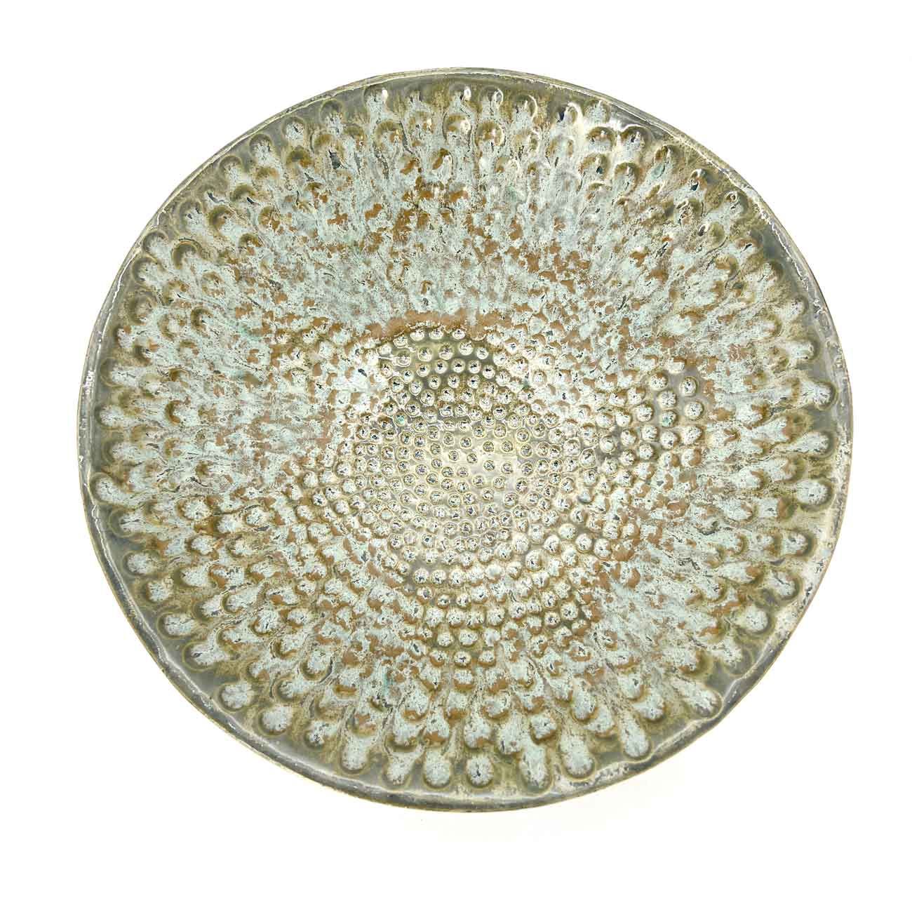 Rond beige keramisch bord met een gestructureerd stippenpatroon.