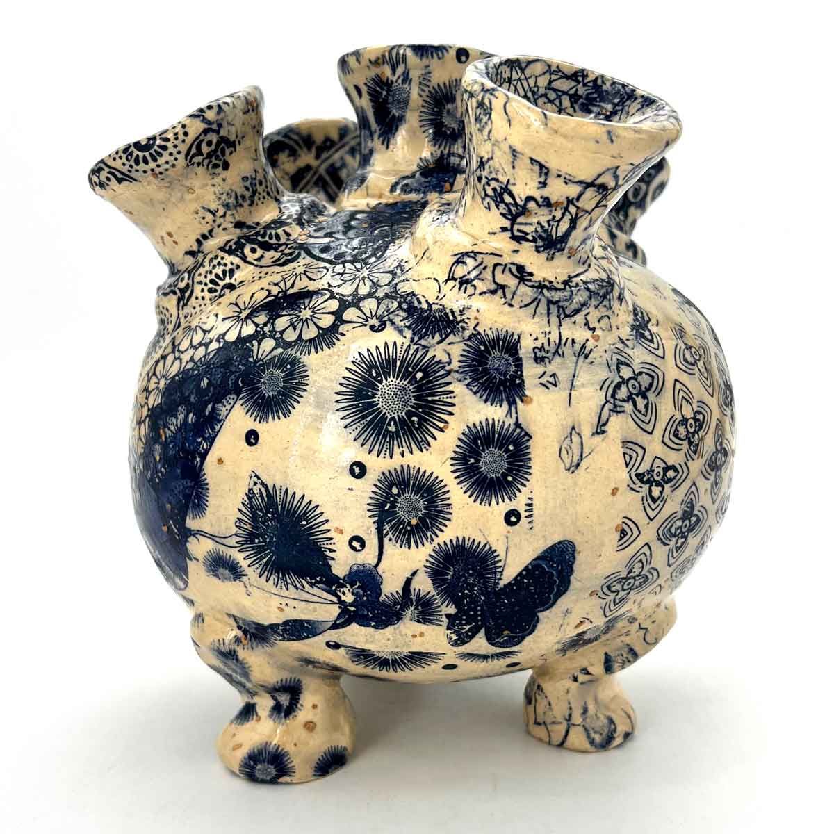 Blauw-crème keramische vaas met bloemmotieven en kleine voetjes.