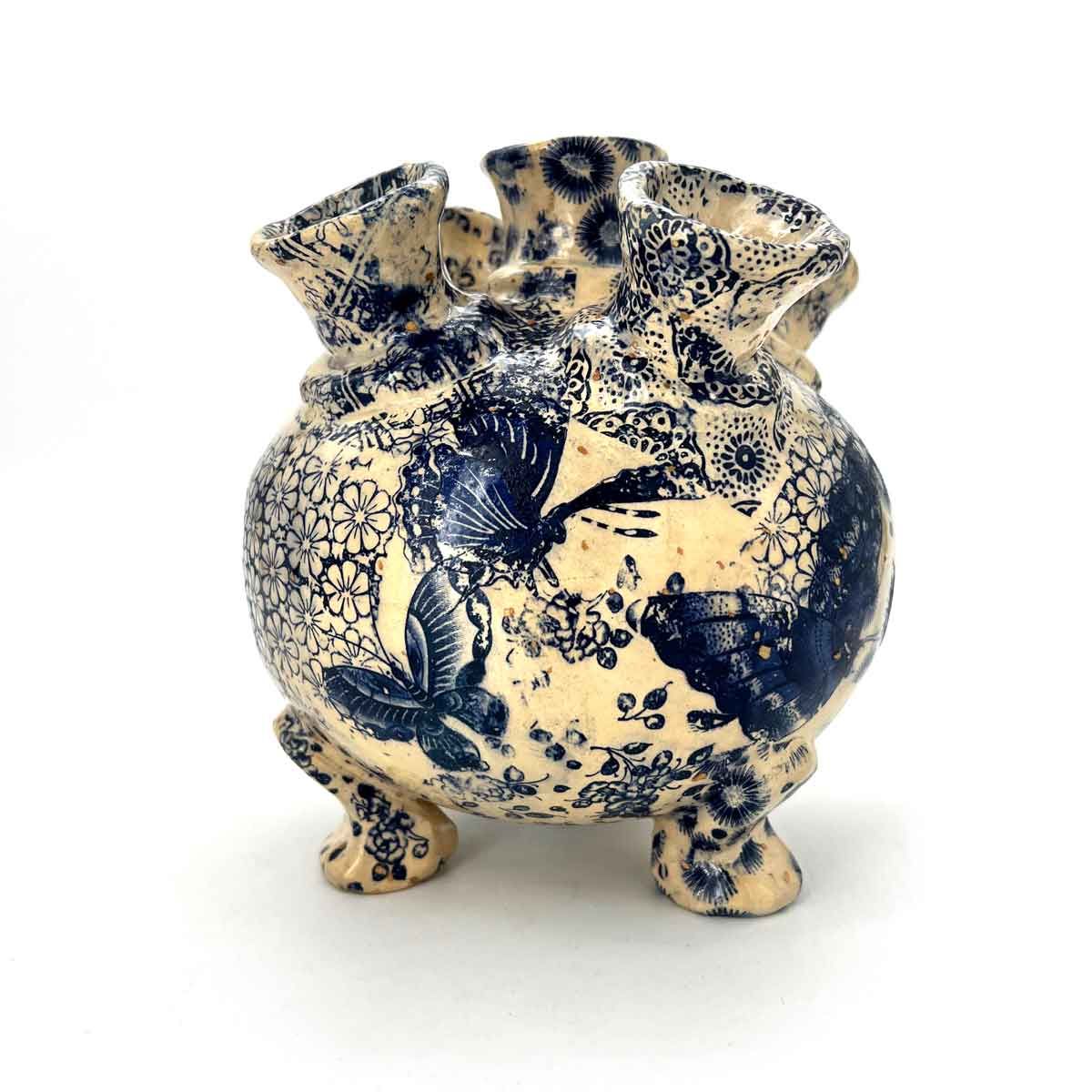 Blauw-crème keramische vaas met vier kleine voetjes en twee handvatten, versierd met ingewikkelde bloemmotieven.