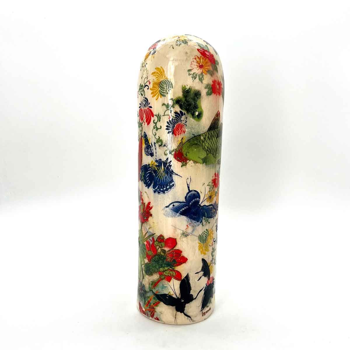 Hoge, ronde keramische vaas met een kleurrijk bloemenpatroon op een witte achtergrond.