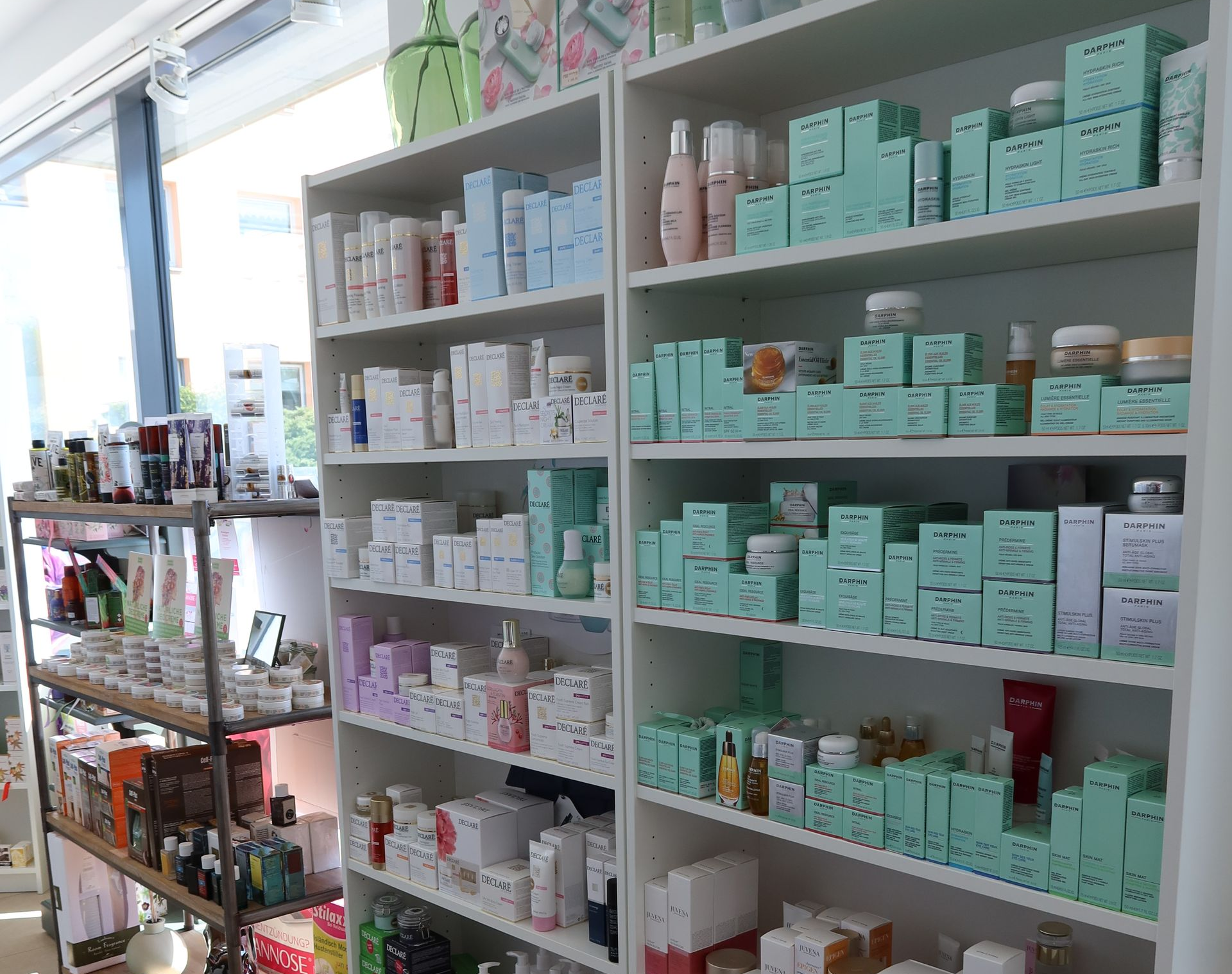 Regale voller Hautpflegeprodukte, meist verpackt, in einem hell erleuchteten Laden.