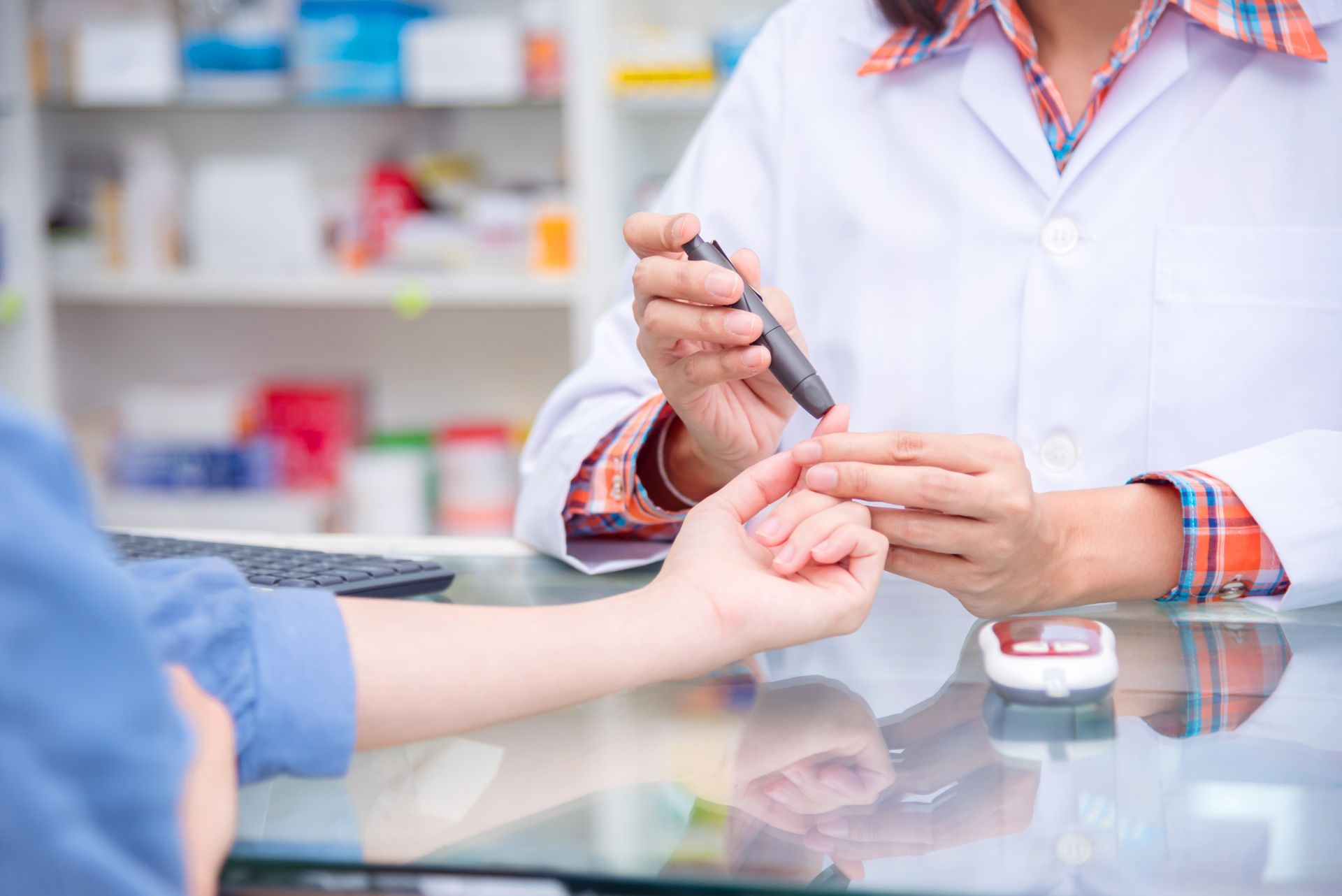 Ein Apotheker misst den Blutzucker eines Patienten mit einem Blutzuckermessgerät am Apothekenschalter.