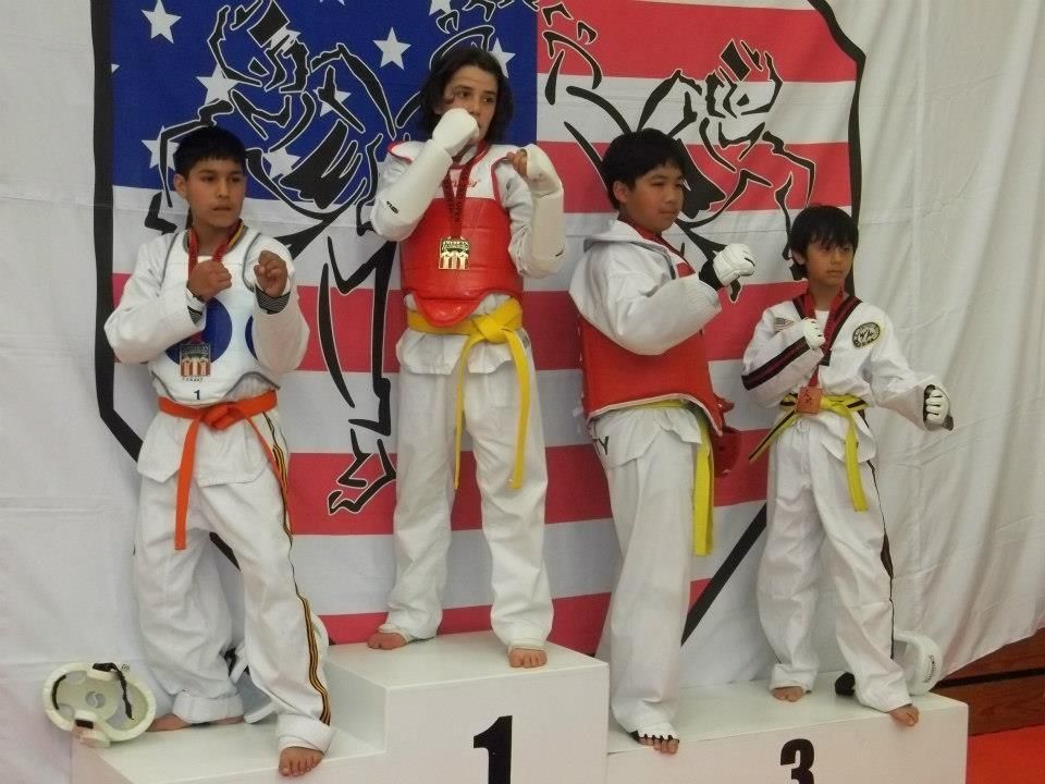 A group of kids are standing on a podium with the number 1 and 3 on it