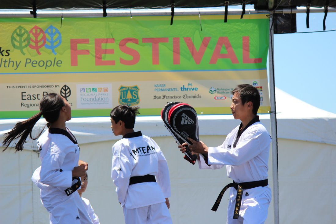 A group of people are practicing martial arts in front of a festival banner.