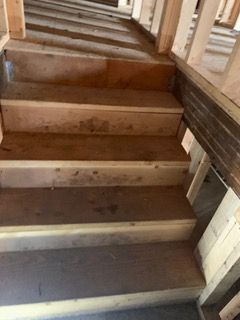 Unfinished wooden staircase under construction, viewed from the bottom