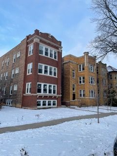 Snow-covered brick apartment buildings on a winter street corner