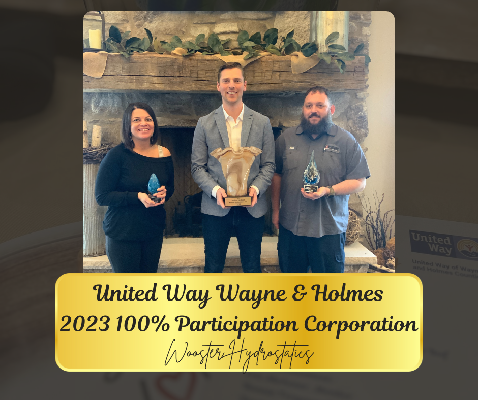 Three people holding awards in front of a fireplace, celebrating 