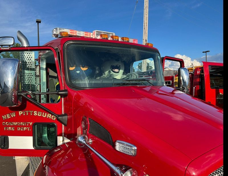 Red fire truck with open doors, a firefighter in the cab, 