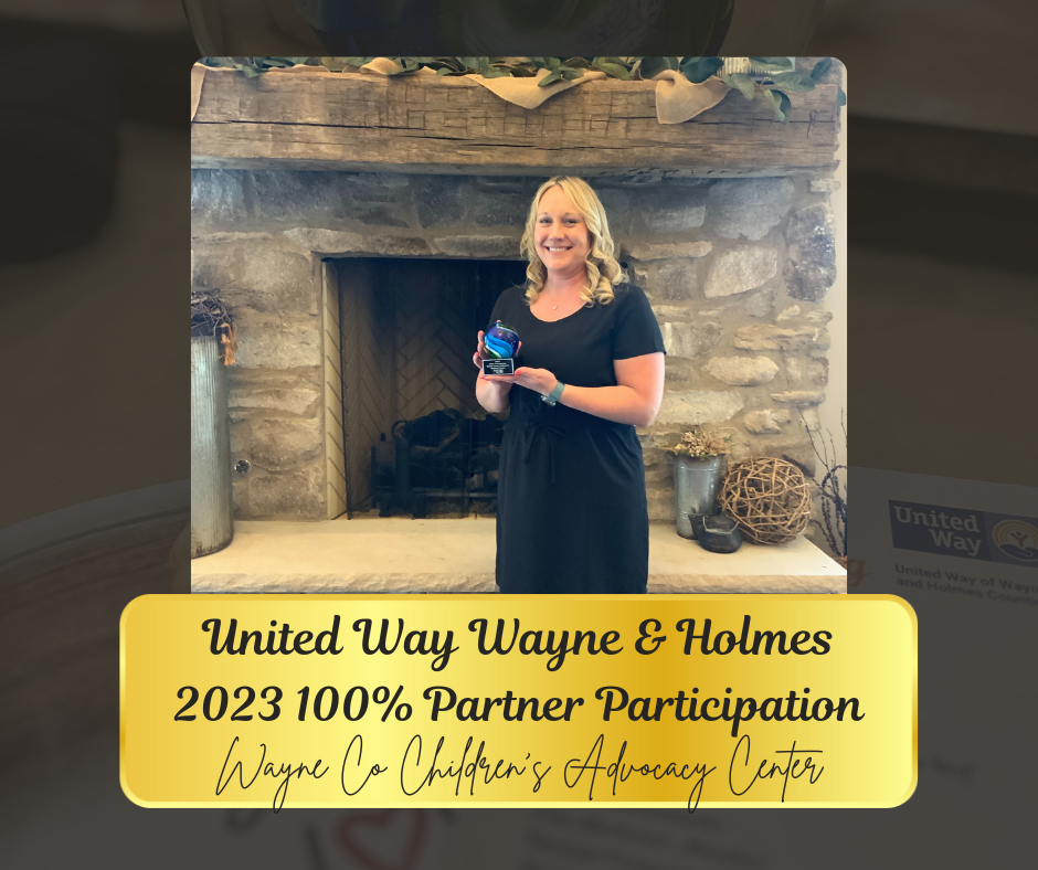 Woman holding an award in front of a fireplace. Award states 