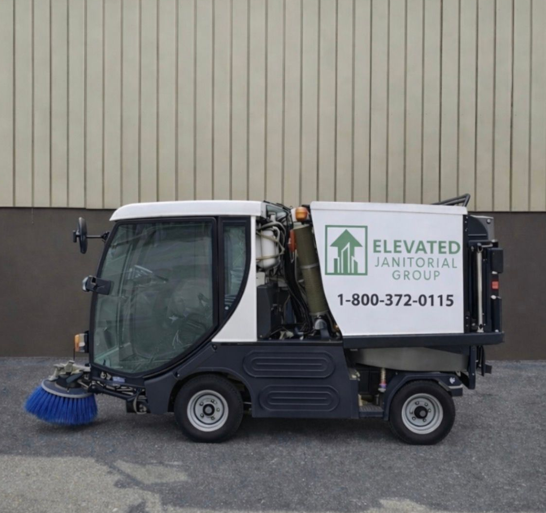 Underground parking garage with cars parked in marked spaces; green and white columns and ceiling fixtures.