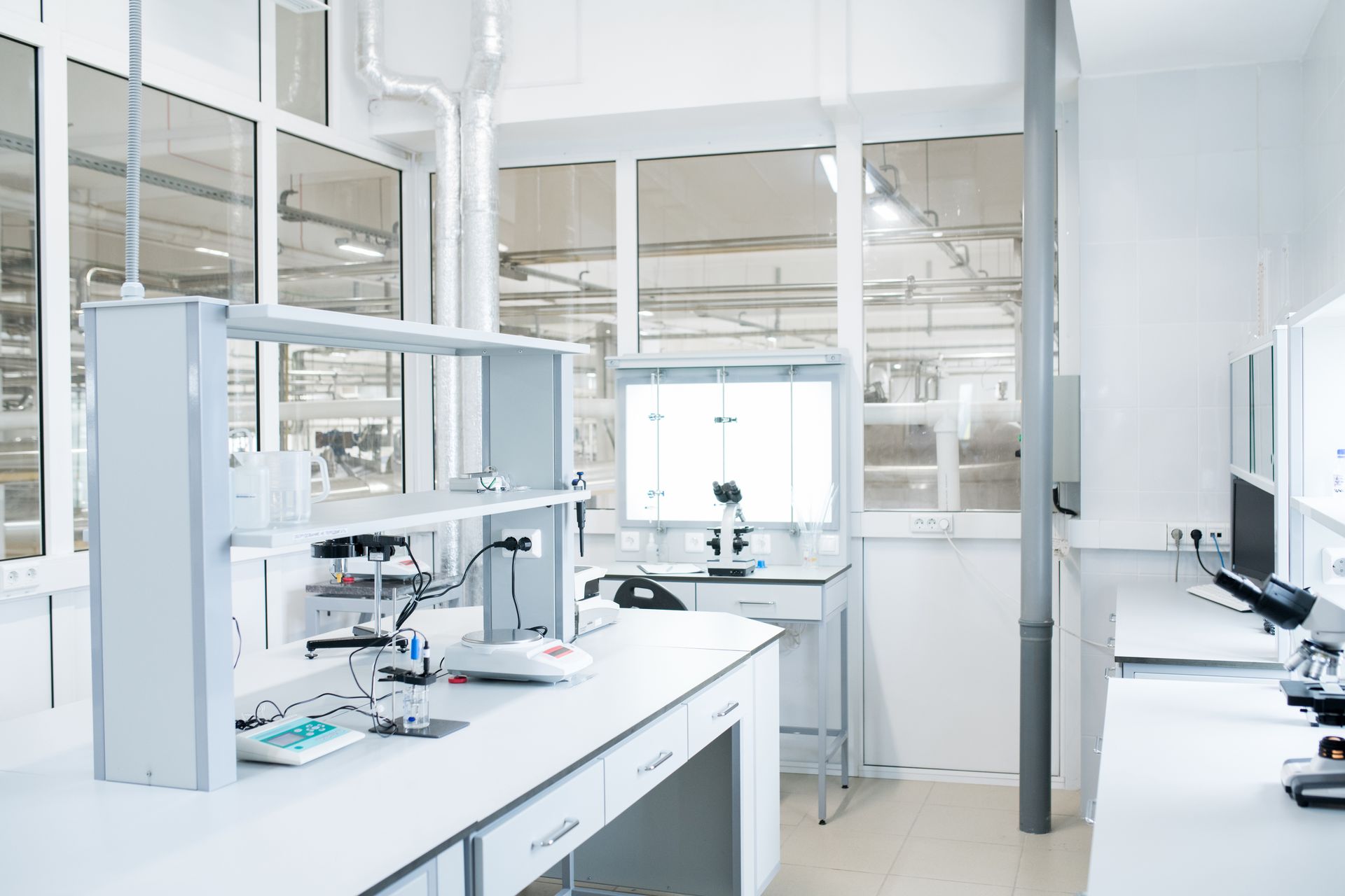 Bright, modern laboratory with white surfaces and large windows; lab equipment on counters.