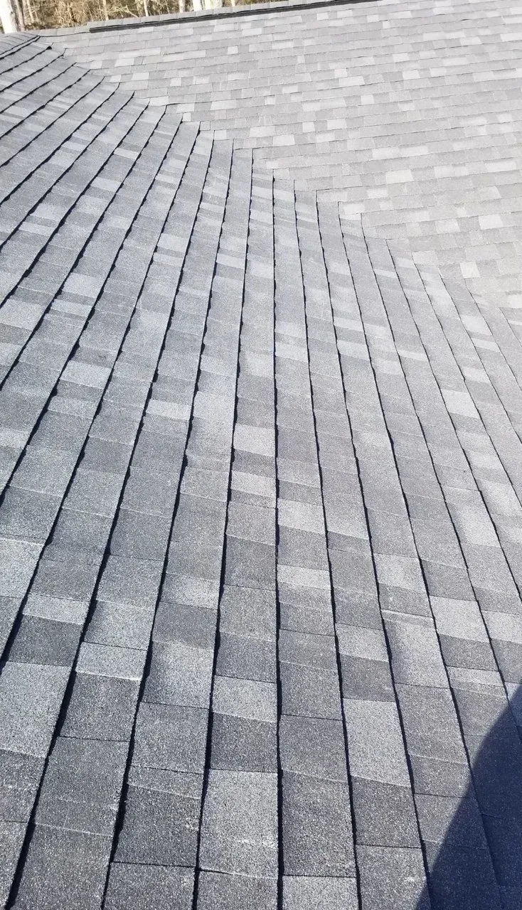 Gray shingled roof with a steep diagonal section and visible pattern lines