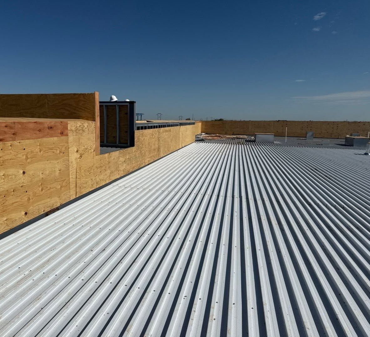 Aerial view of workers on a flat rooftop with orange and blue building sections