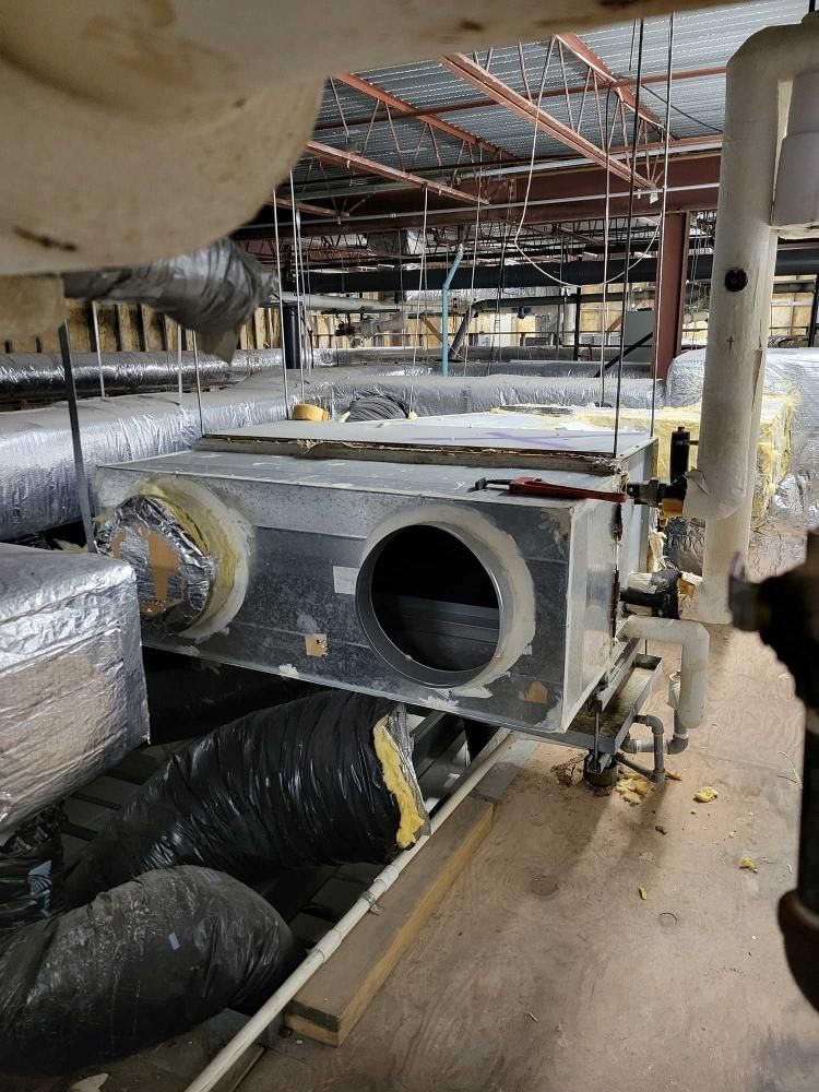 Construction site ductwork with large insulated HVAC ducts and exposed ceiling framing