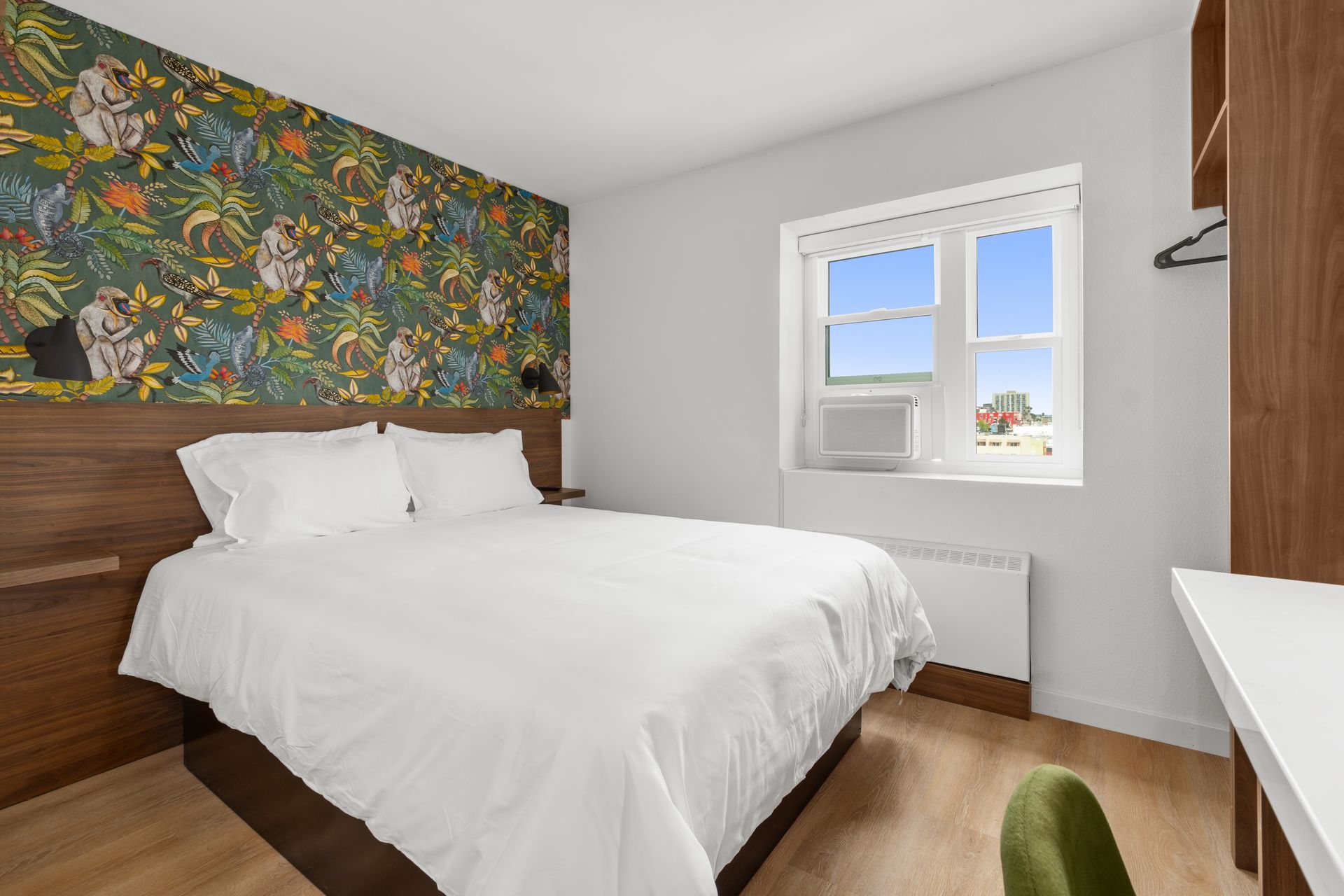 A hotel room with a king size bed and a window.