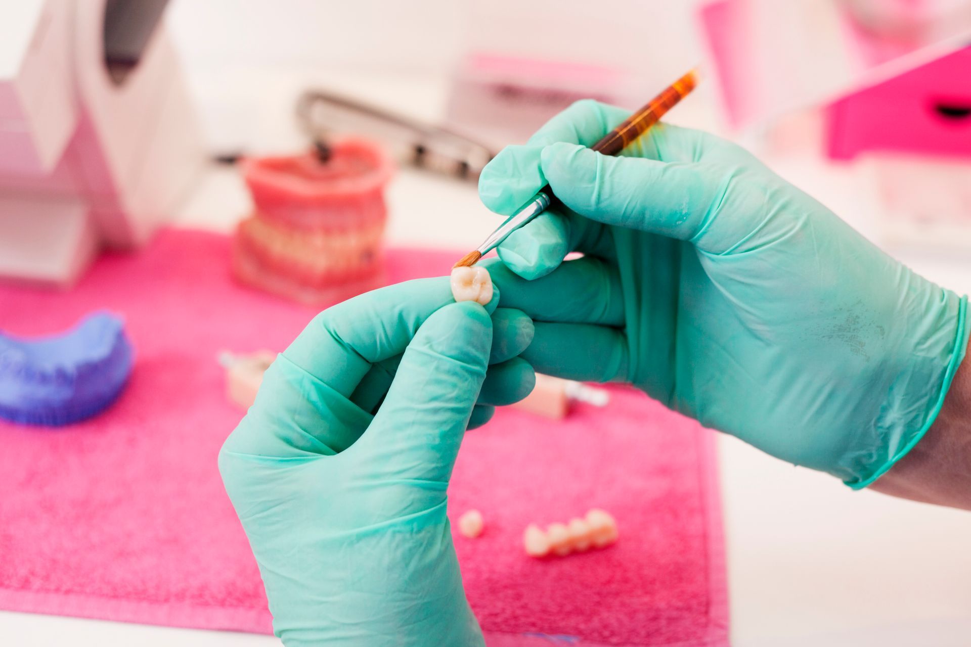 Dental Technician Working on a Tooth Crown with Pink Cloth on Table — Mount Waverley, VIC — Mount Waverley Dental