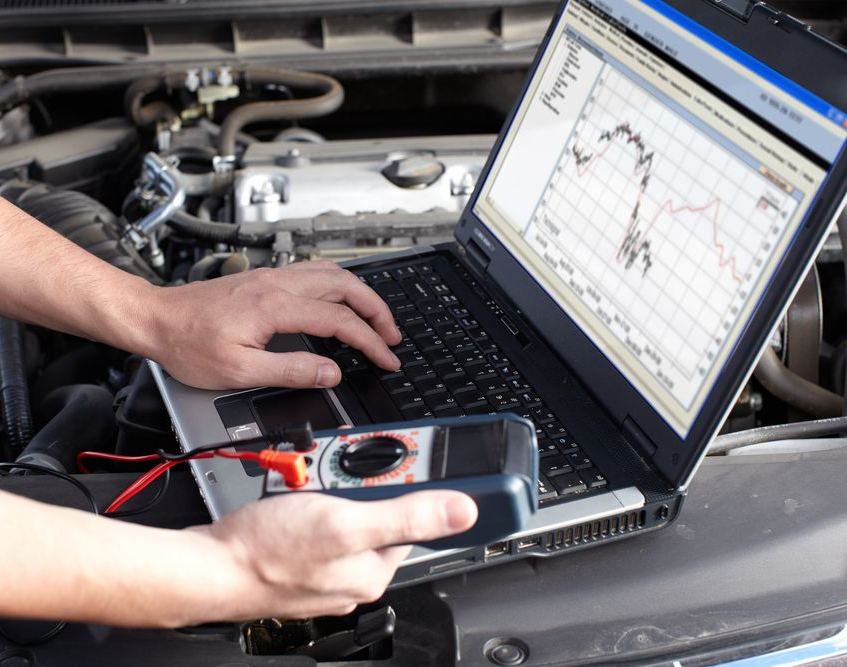 a Mechanic Uses a Laptop and Multimeter to Diagnose a Car — Coopers Auto Care in South Lismore, NSW