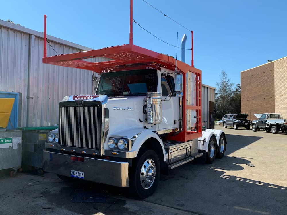 A White Semi Truck With A Red Trailer Is Parked In Front Of A Building — All Port Smash Repairs in Port Macquarie, NSW