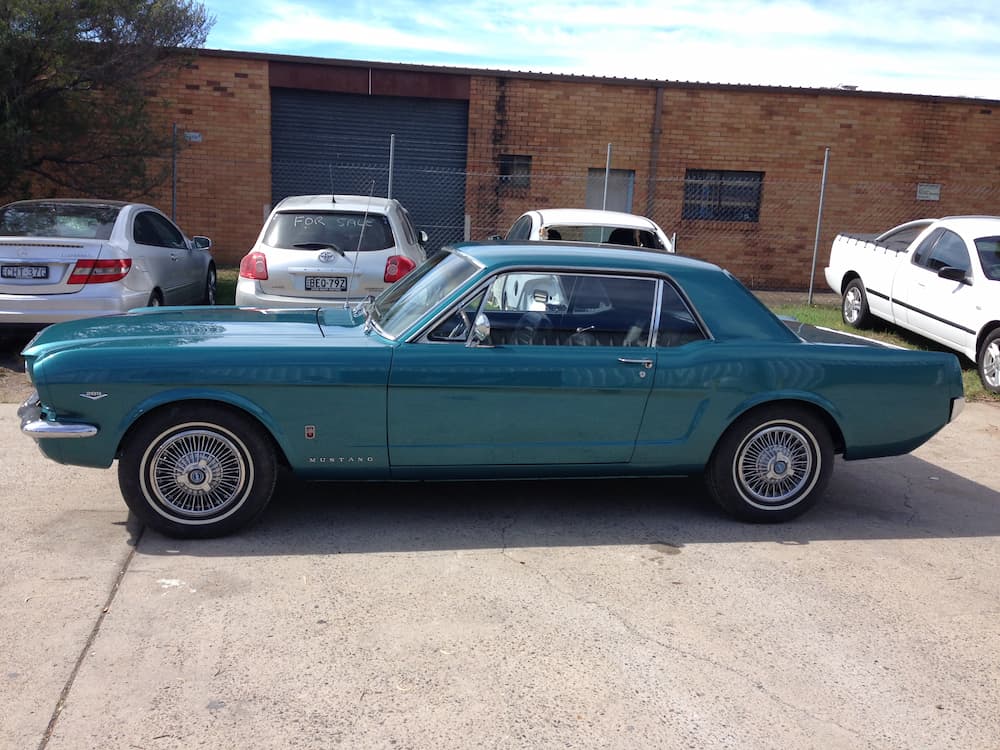 A Blue Mustang Is Parked In Front Of A Brick Building — All Port Smash Repairs in Kempsey, NSW