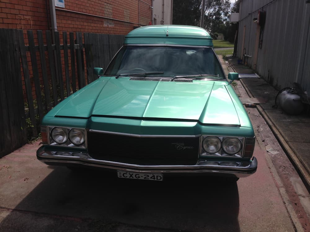 A Green Car Is Parked On The Side Of The Road Next To A Fence — All Port Smash Repairs in Wauchope, NSW