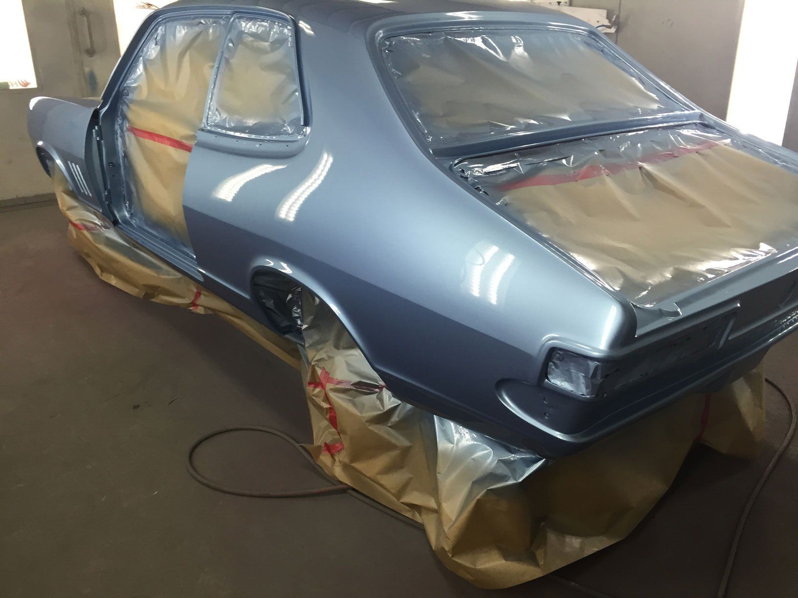 A Blue Car Is Being Painted In A Garage — All Port Smash Repairs in Port Macquarie, NSW