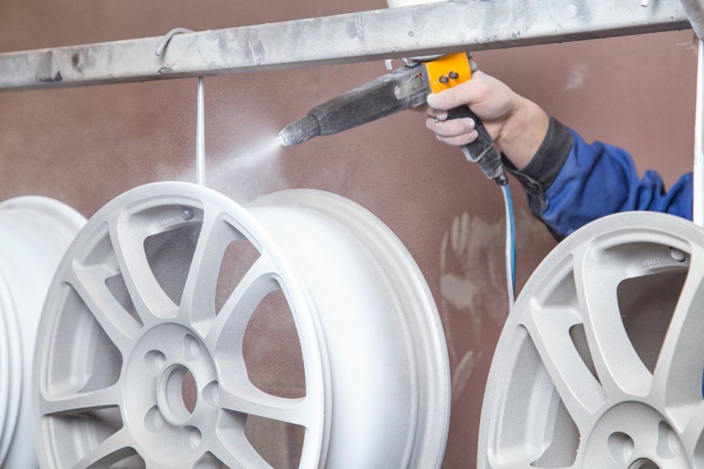 Mechanic Spraying Paint On Wheel — All Port Smash Repairs in Port Macquarie, NSW