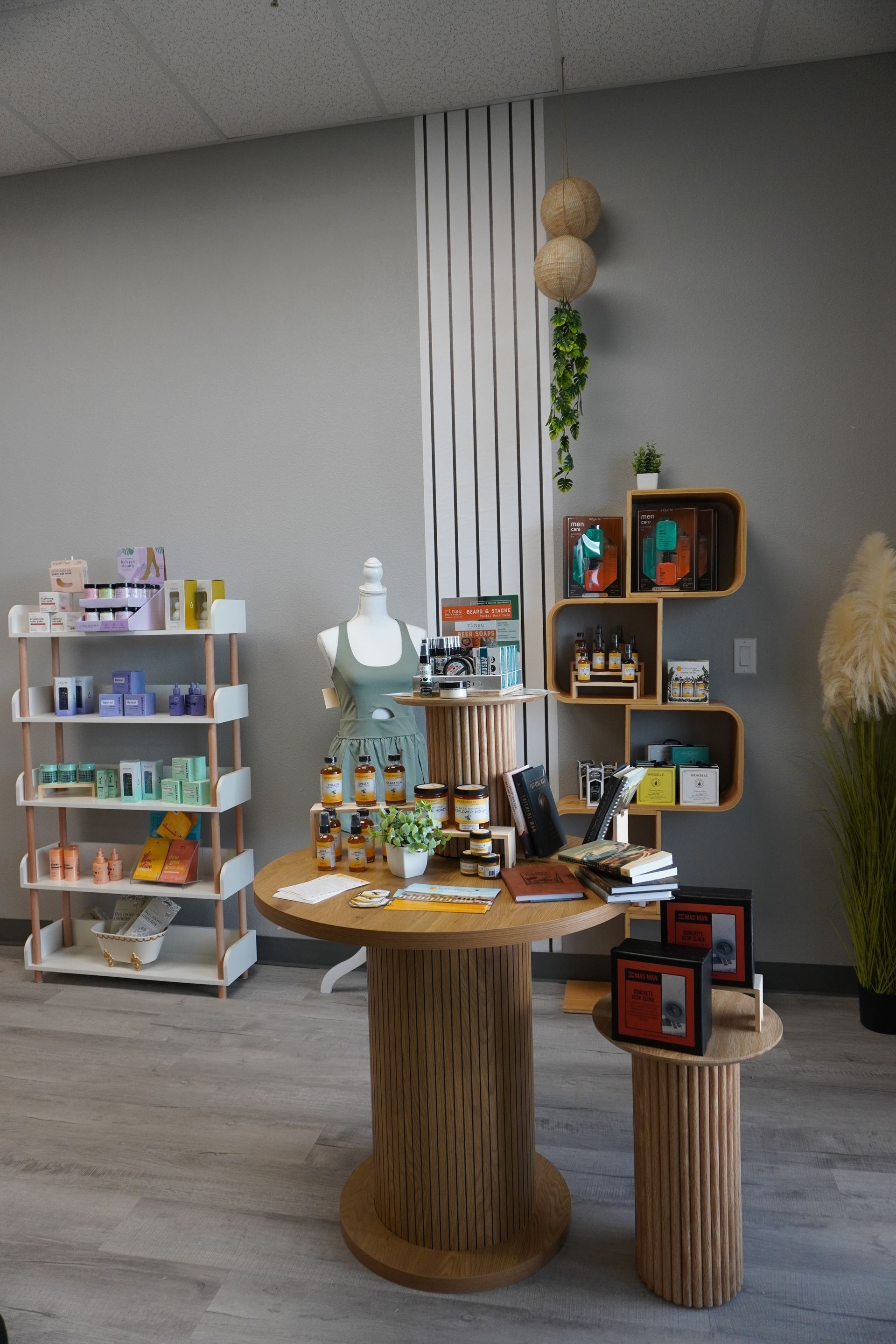 Retail display with products on shelves and tables; light wood and pastel colors, with a mannequin. Level Up Falcon