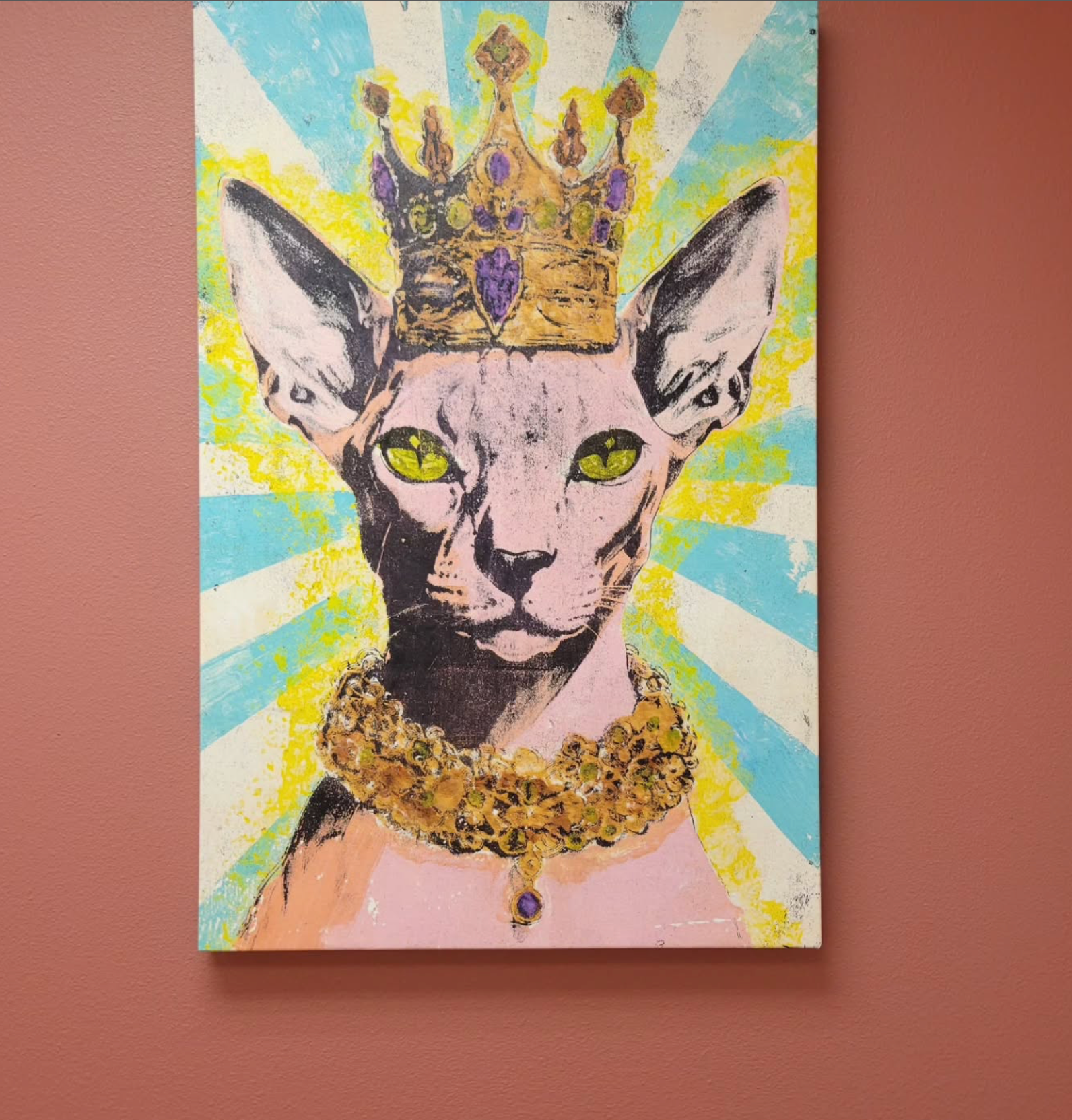 Sphynx cat wearing a jeweled crown and collar, against a background of turquoise rays. Level Up Falcon