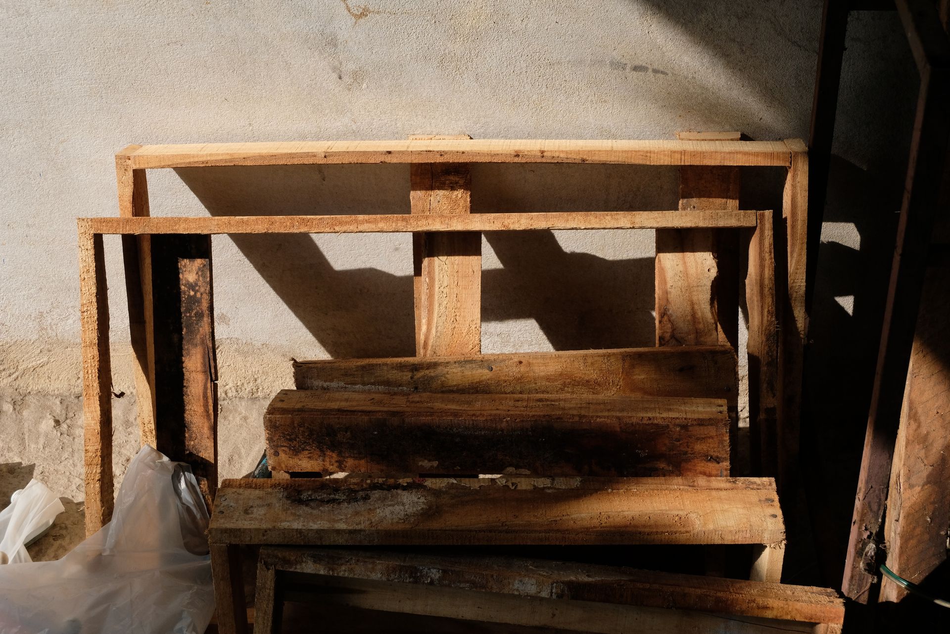A pile of wooden pallets are stacked on top of each other