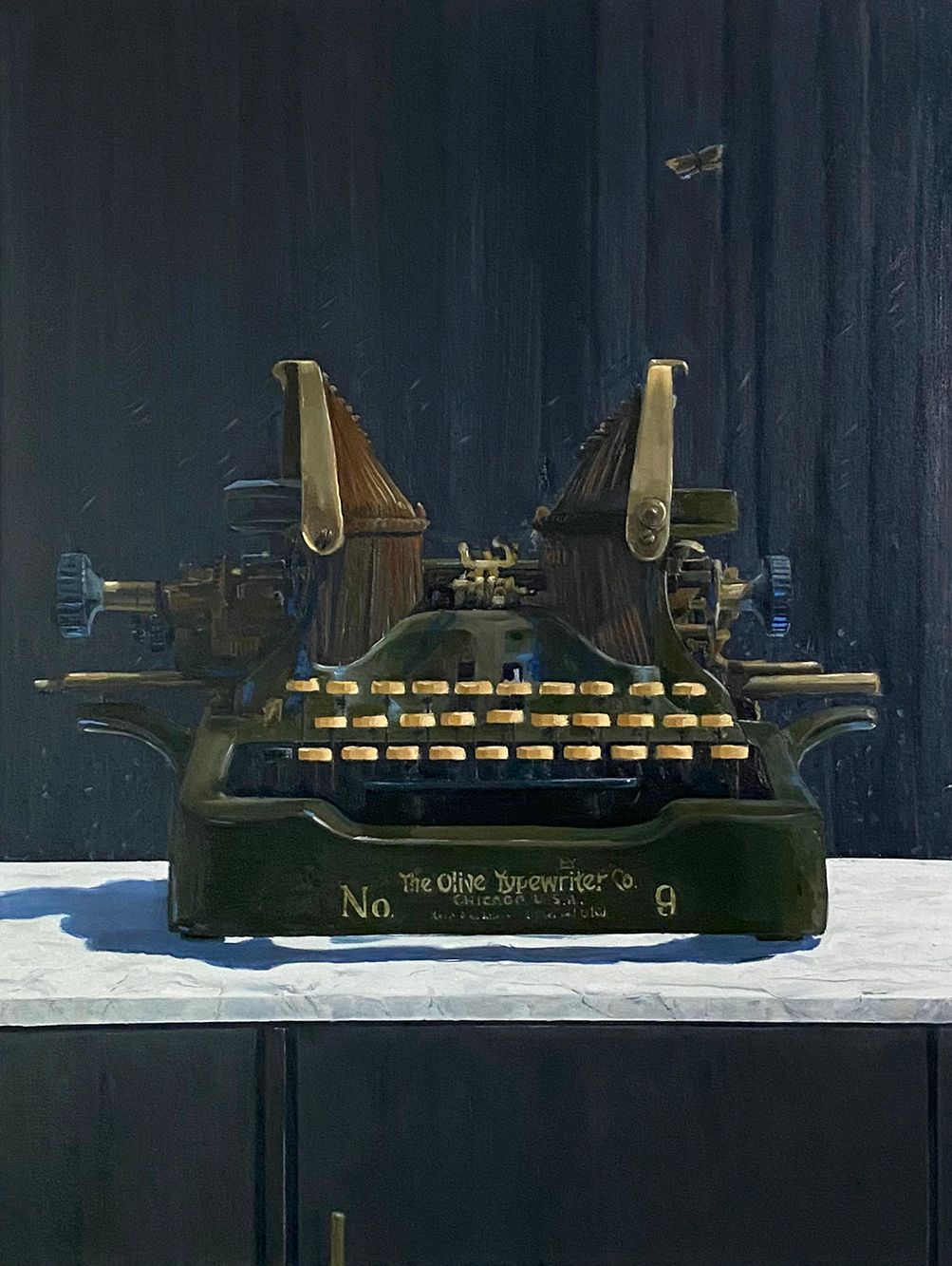 An old typewriter is sitting on a table in front of a wall