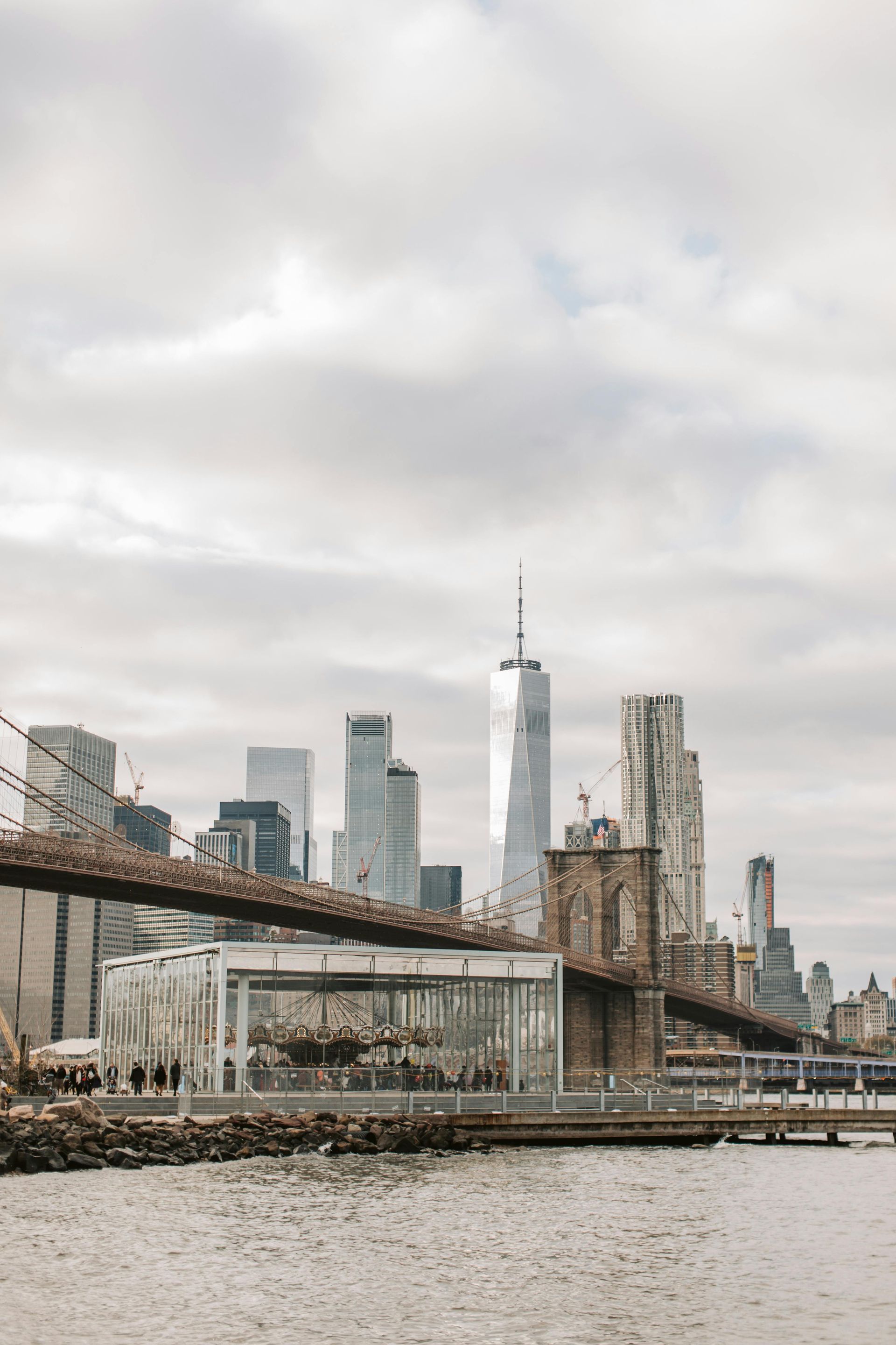 A bridge over a body of water with a city skyline in the background.