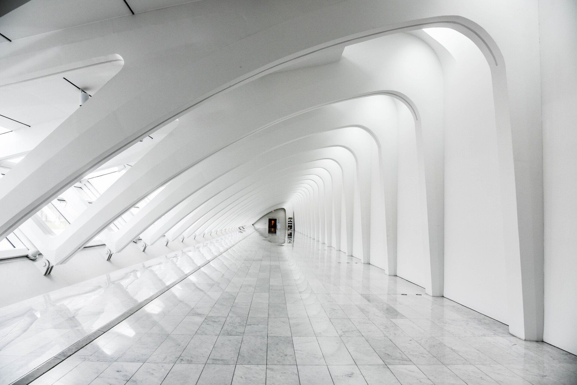 A black and white photo of an empty hallway in a building.