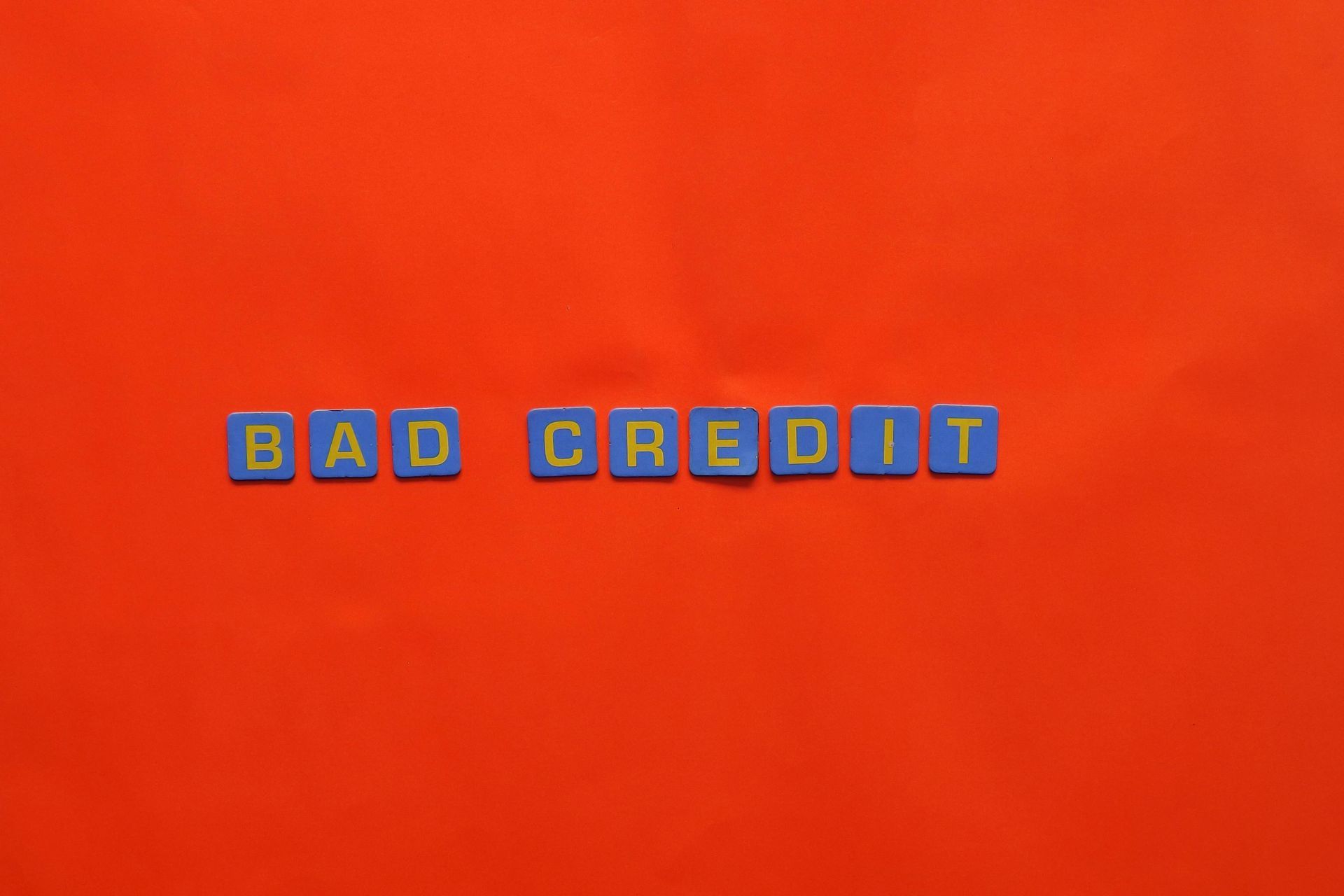 The word bad credit is written in blue blocks on a red background.