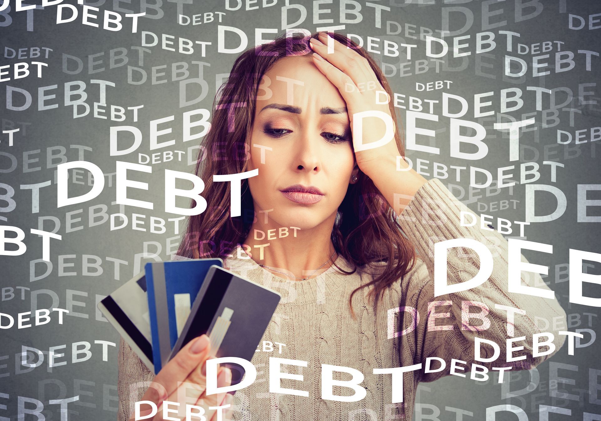 A woman is holding a credit card in front of a background that says debt.