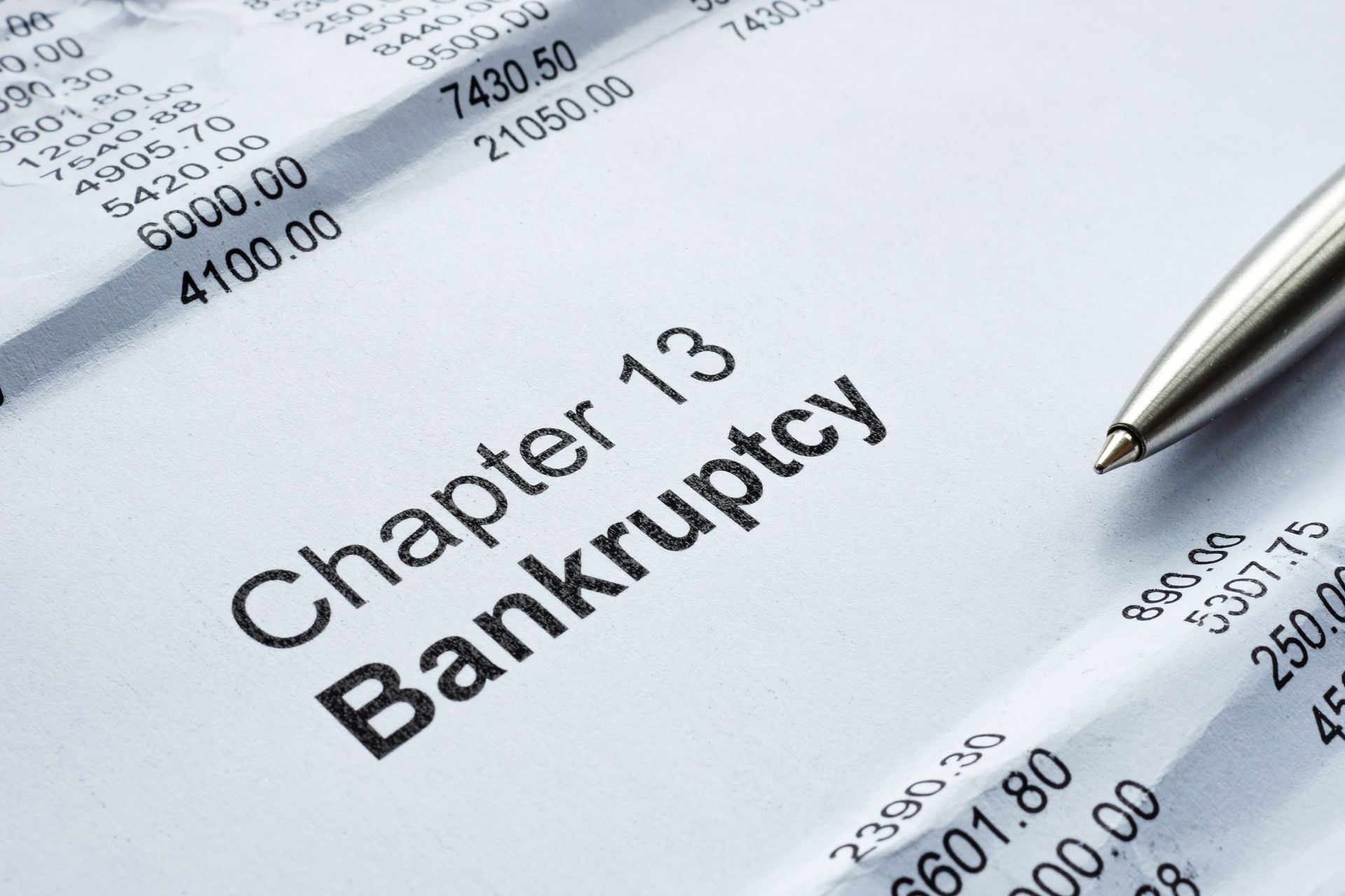 A pen is sitting on a piece of paper that says chapter 13 bankruptcy.
