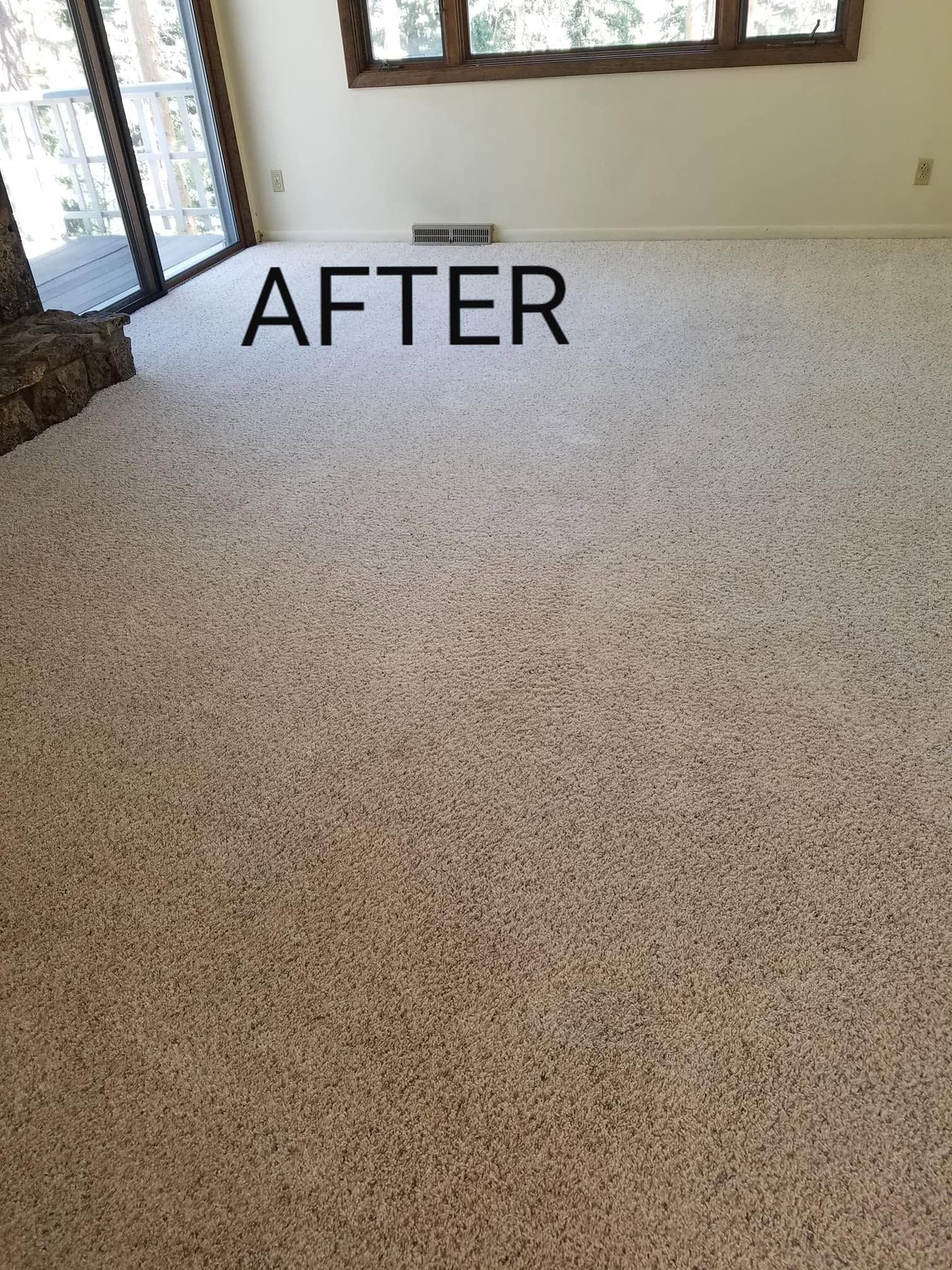 After photo of a speckled beige carpeted room with windows and a stone wall