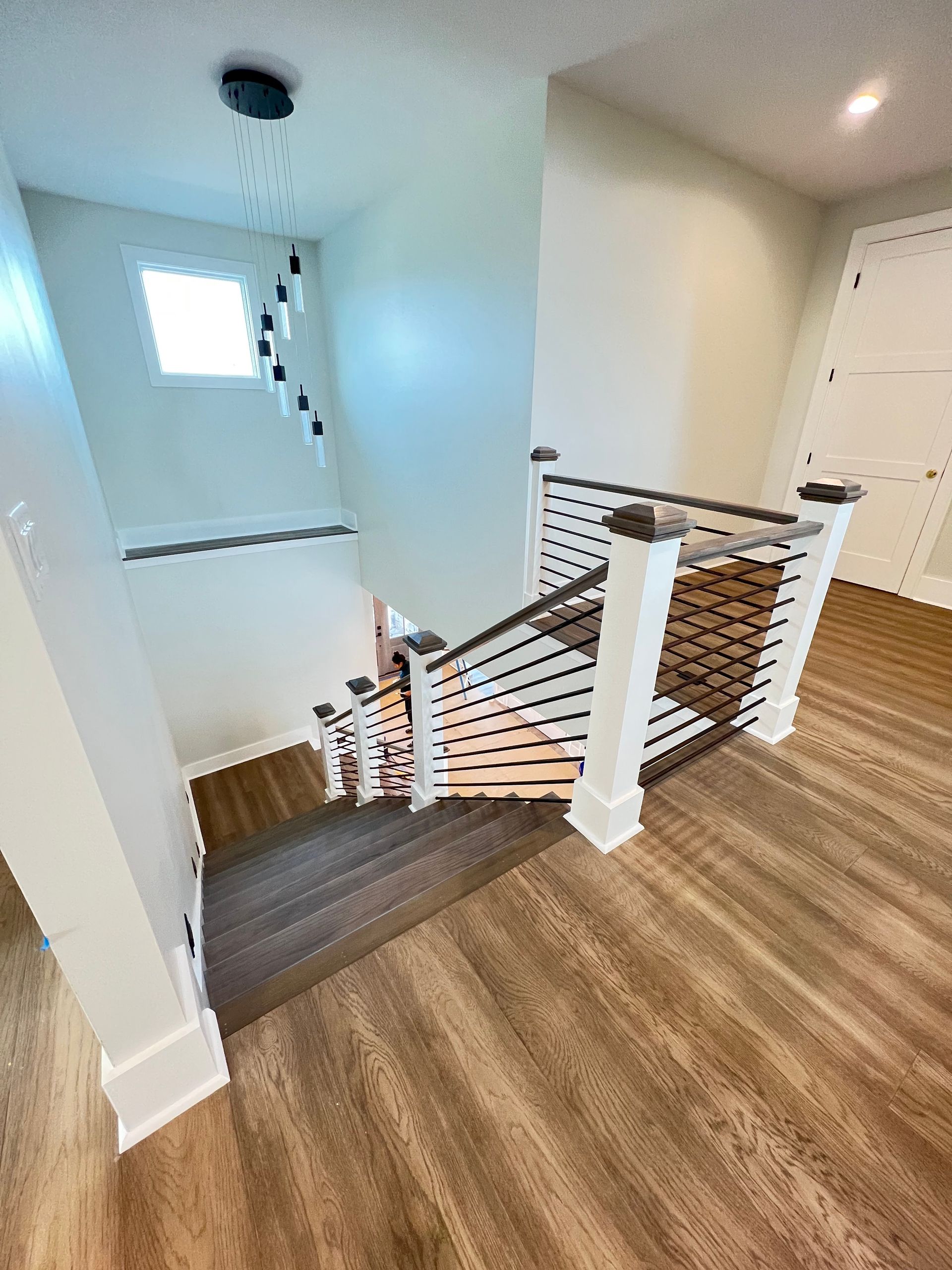 A staircase with a wooden railing and a wooden floor in a house.