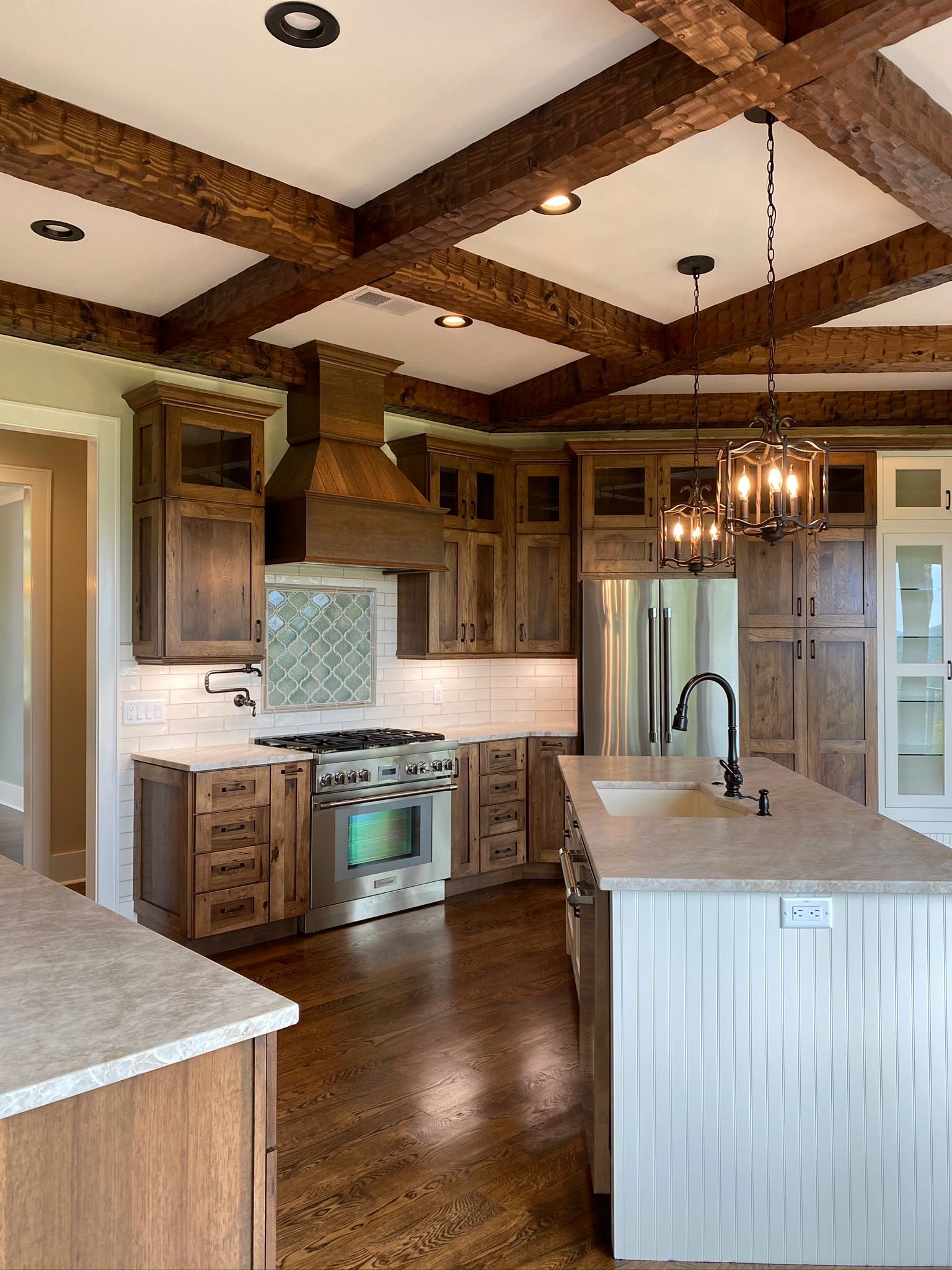 A kitchen with wooden cabinets , stainless steel appliances , and a large island.