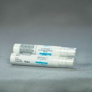 Two white cosmetic tubes stacked. One labeled
