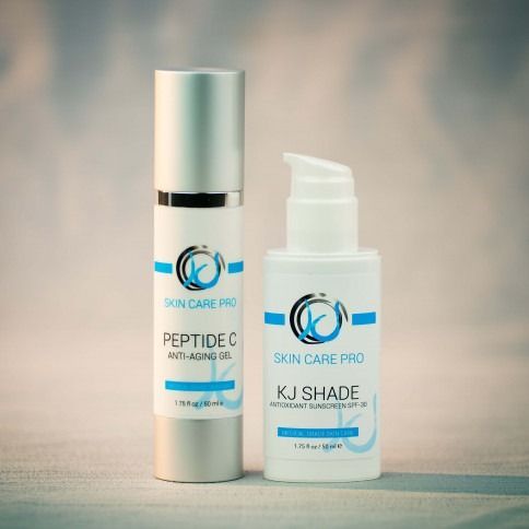 Two skincare product bottles, one silver and one white, with blue and black labeling.