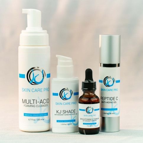 Skincare product bottles with blue and white labels; include a cleanser, serum, and lotion.