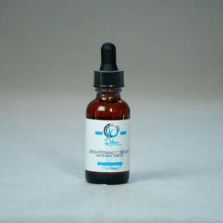 Brown glass dropper bottle of brightening serum on a light surface.