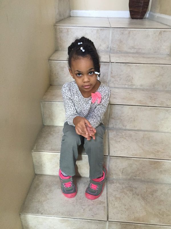 A little girl is sitting on a set of stairs.