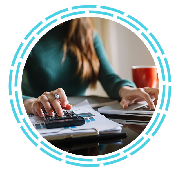 Woman using a calculator and laptop with a cup of coffee.