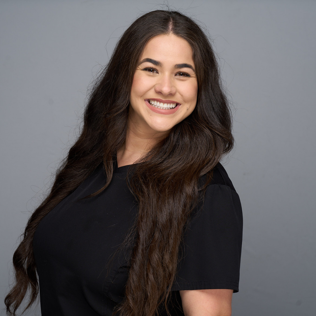 Smiling woman in a black shirt against a gray background