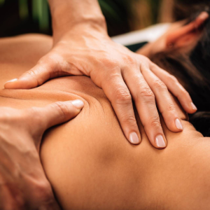 Hands giving a back massage on a person lying face down.
