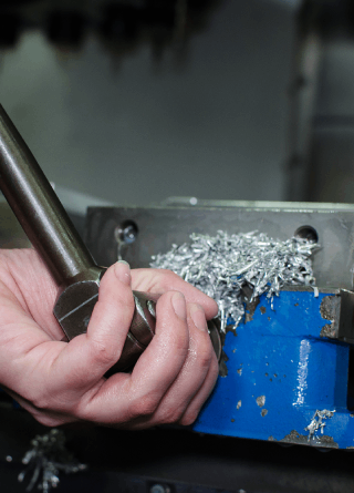 A person is cutting a piece of metal with a machine.
