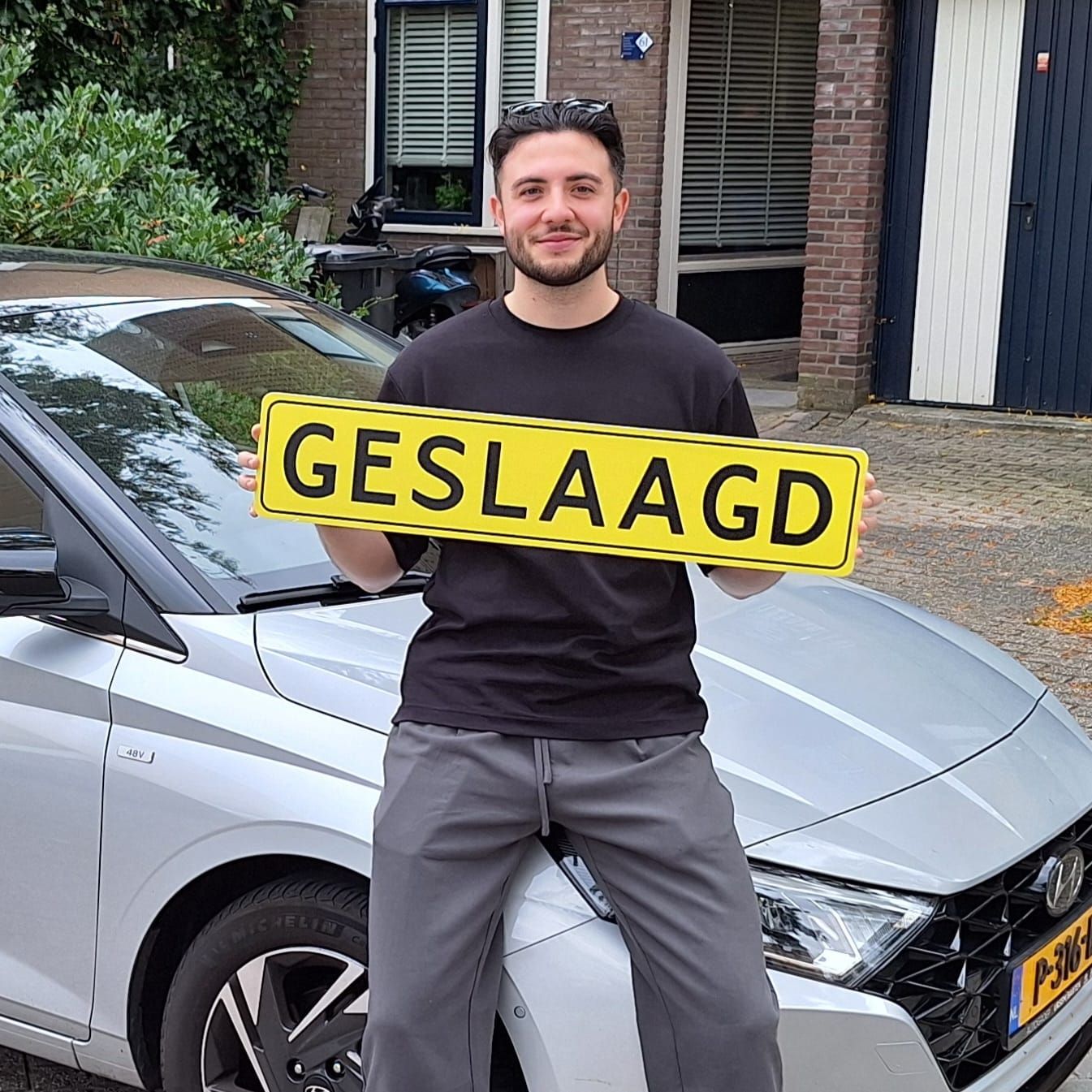 Een man in een zwart shirt houdt een geel