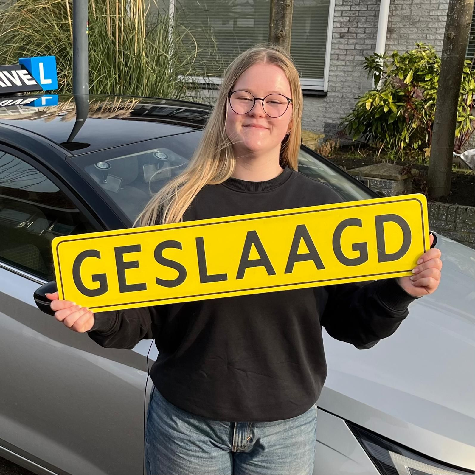 Een persoon houdt een geel bord met de tekst