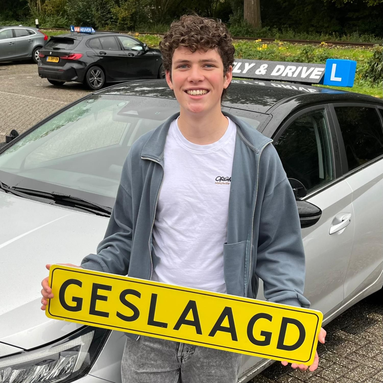 Een lachende chauffeur houdt een geel
